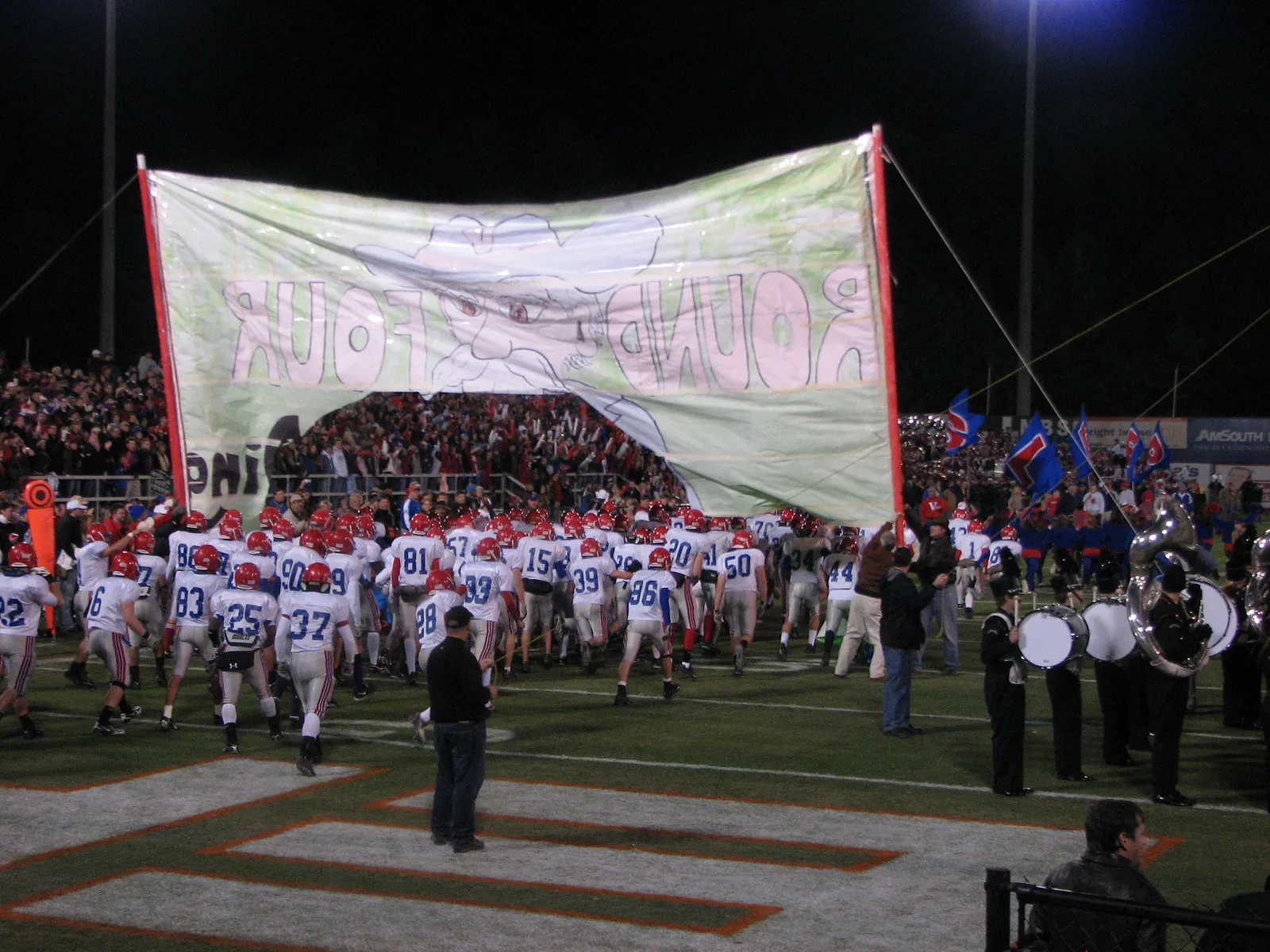 Vestavia Hills players run through a banner before a playoff game against Hoover at the Hoover Met.