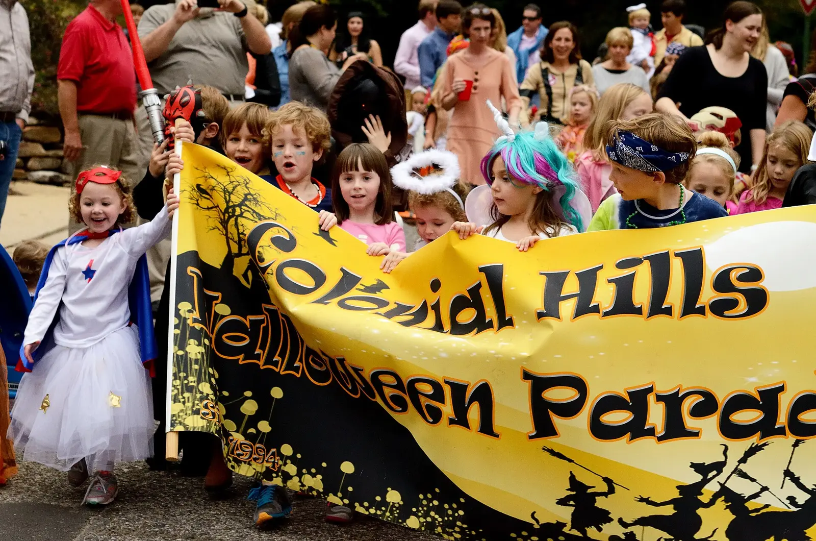 Children in costume carry the banner at the Colonial Hills Halloween Parade in the Birmingham area.